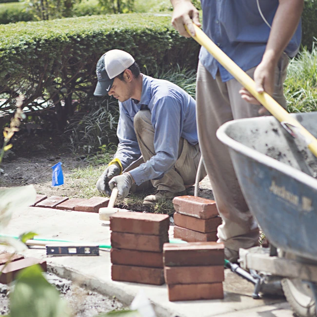 Lawn and Landscape Solutions workers installing a new walkway and landscape bed in Overland Park, KS.